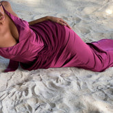Woman in a pink dress lying on the sand